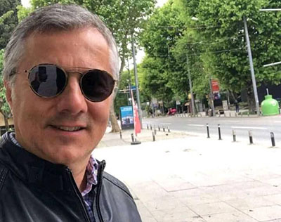 Foto ilustrativa de um homem com óculos escuros ao ar livre, representando um Sugar Daddy.